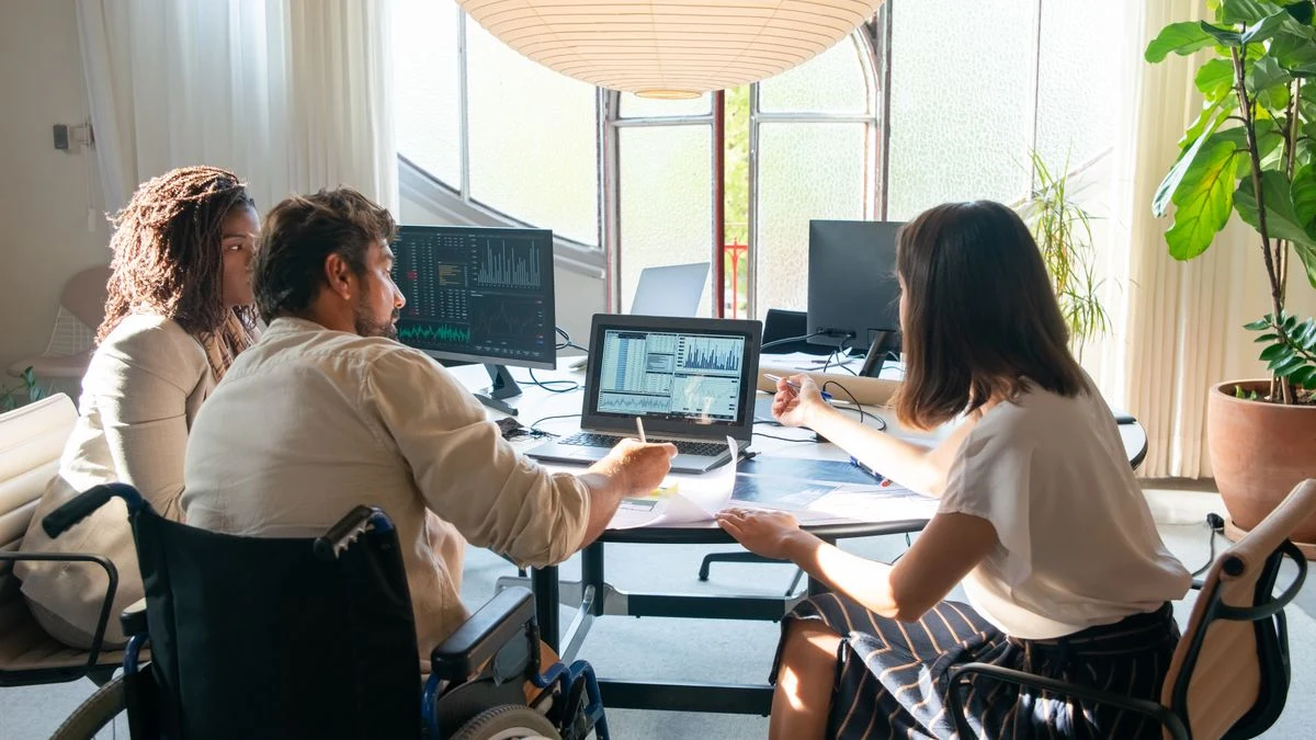 Marketing colleagues discussing digital campaign charts on a laptop