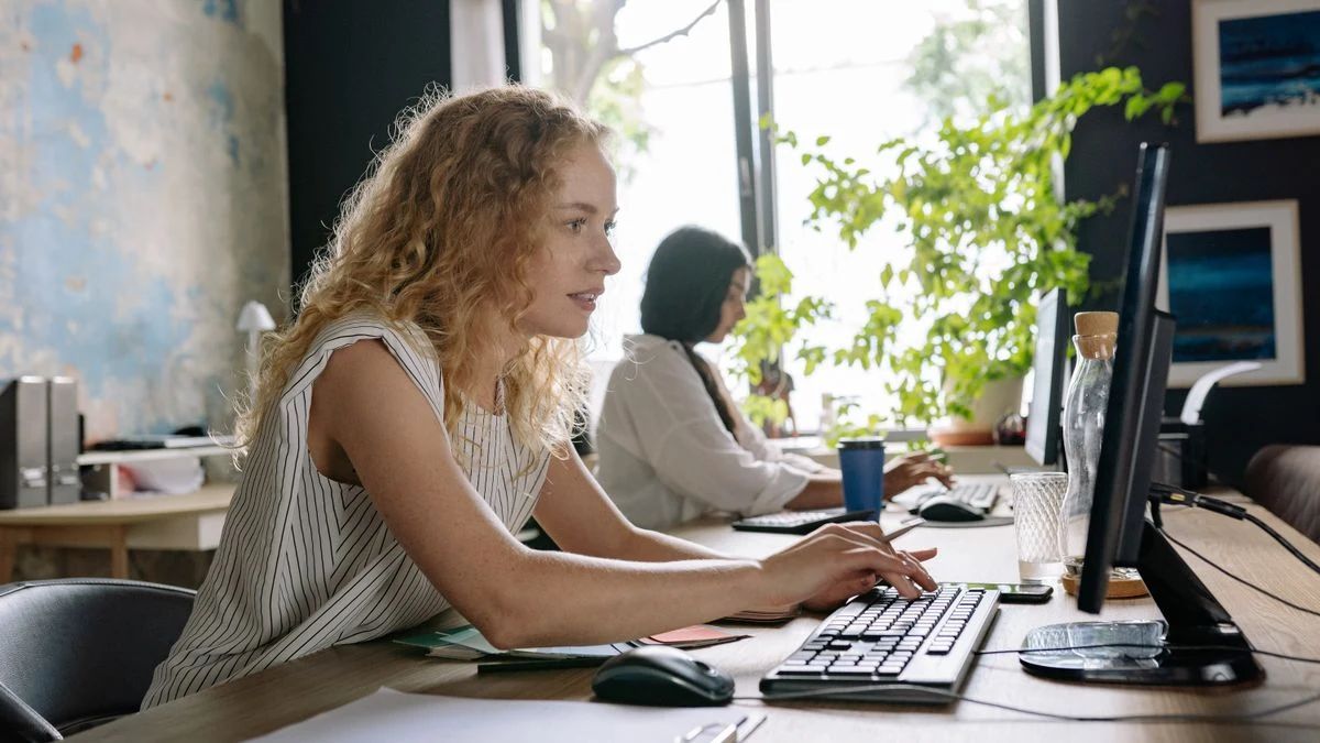 Professionals concentrating on digital work at computers in a bright office